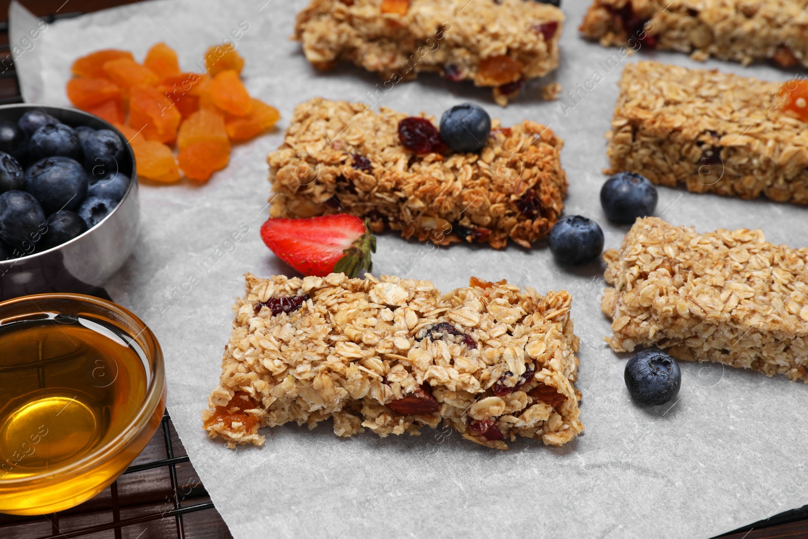 Photo of Tasty granola bars and ingredients on table