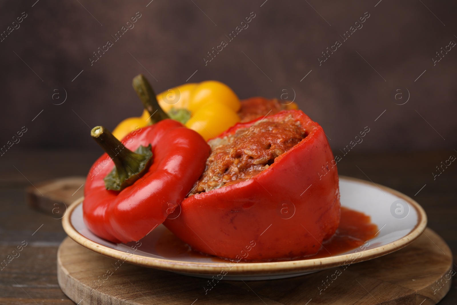 Photo of Delicious stuffed bell peppers served on wooden table