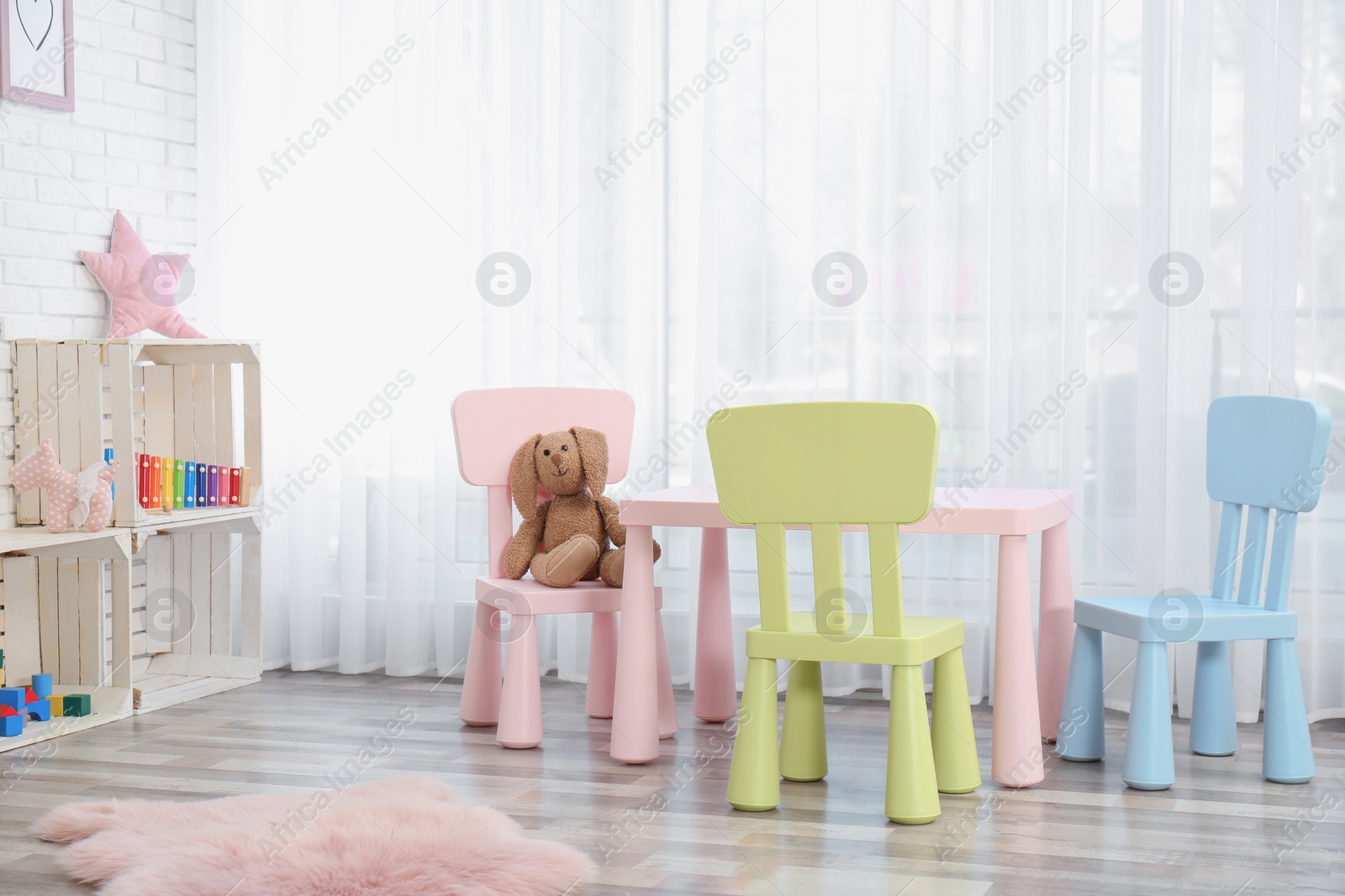 Photo of Cozy kids room interior with table, chairs and toys