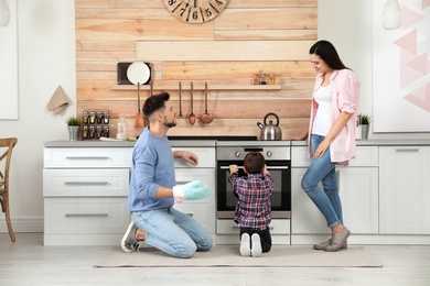 Happy family baking food in oven at home