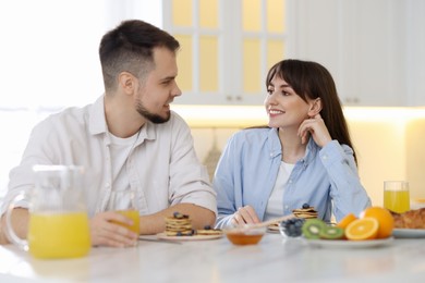 Photo of Happy couple having tasty breakfast at home