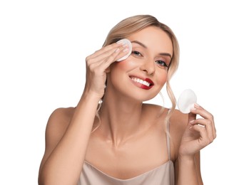 Photo of Smiling woman removing makeup with cotton pads on white background