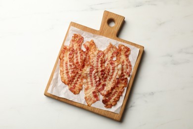 Delicious fried bacon slices on white marble table, top view
