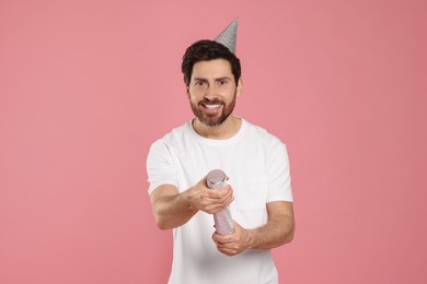 Photo of Happy man with party popper on pink background