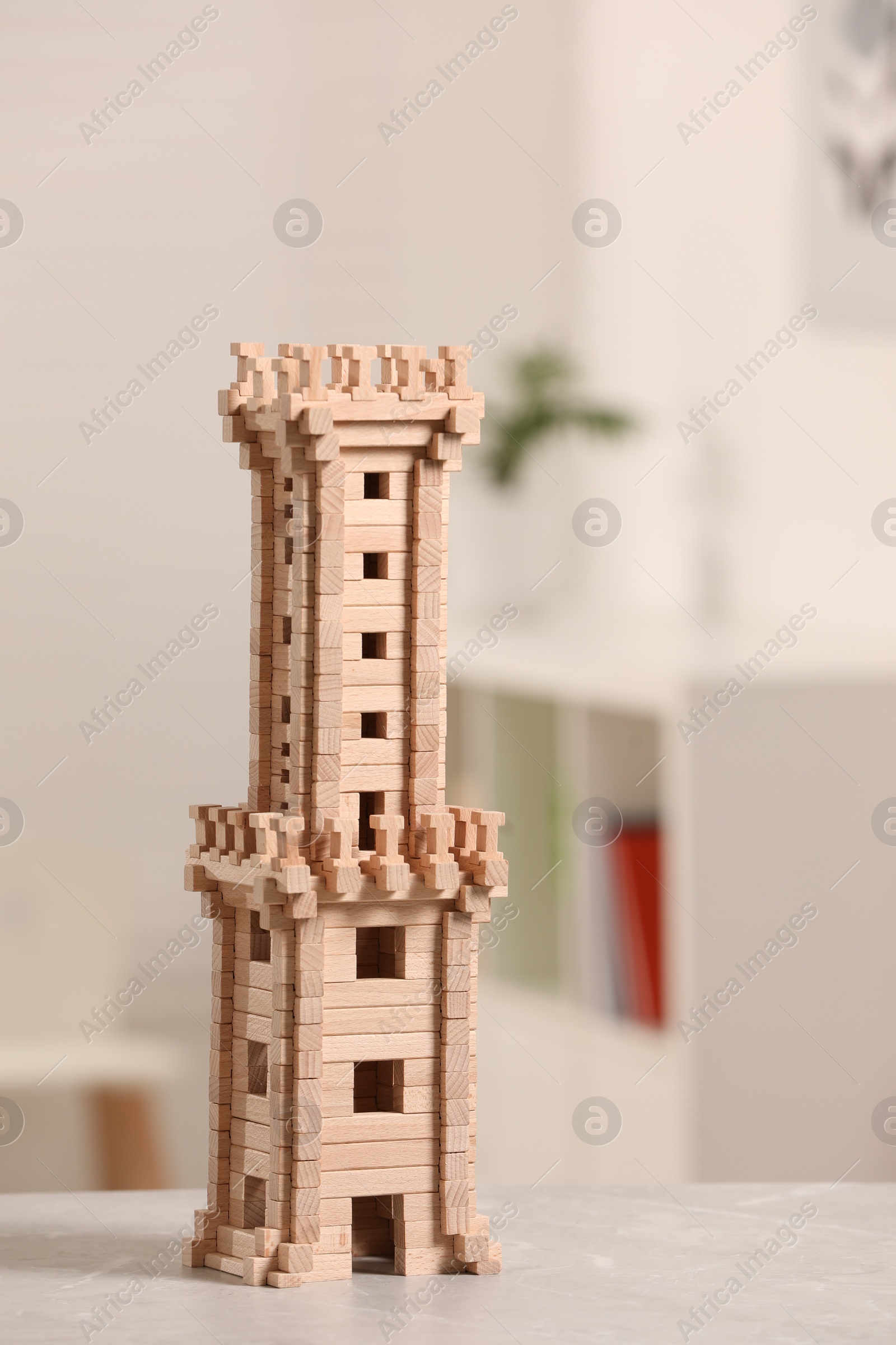 Photo of Wooden tower on table indoors, closeup. Children's toy