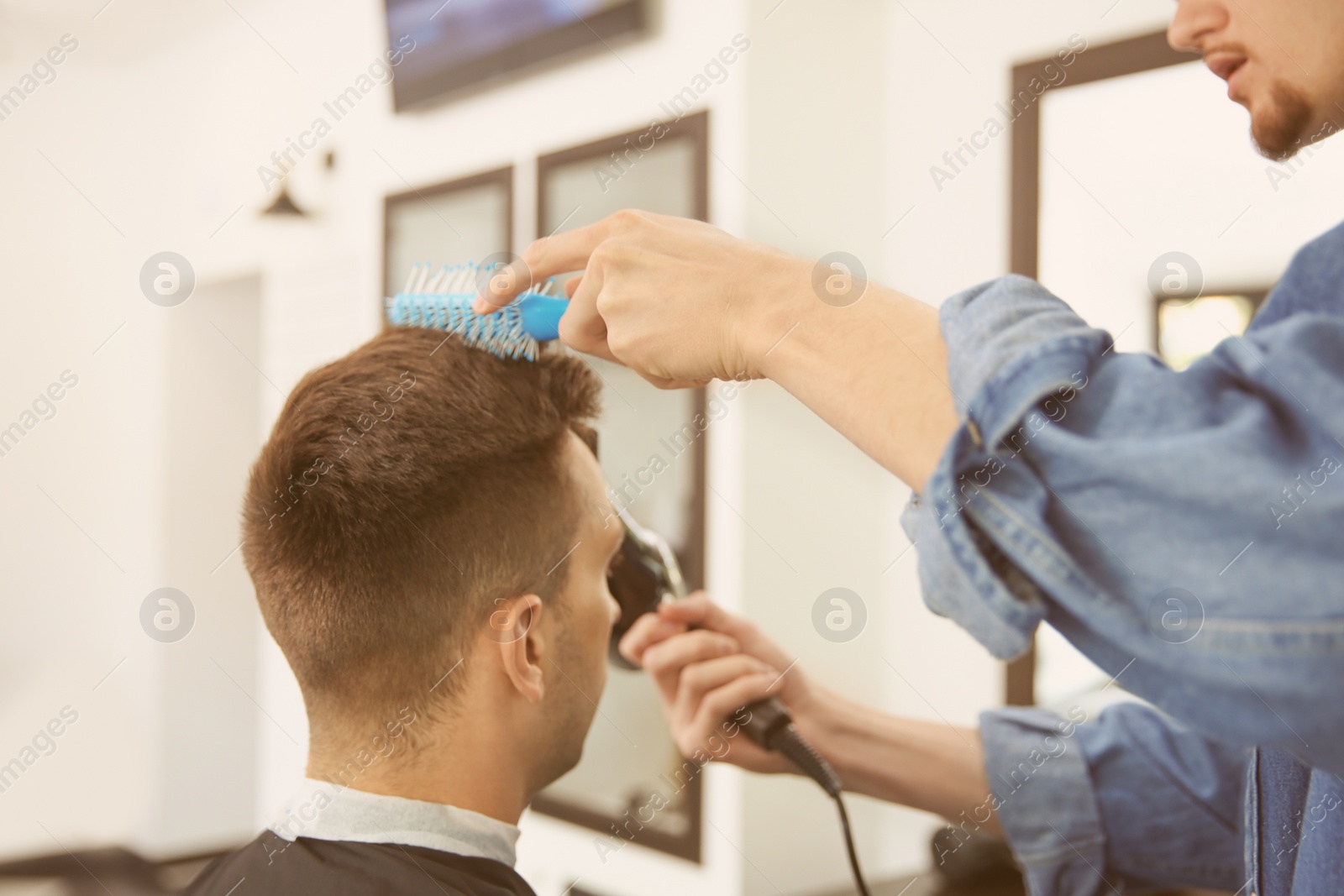 Photo of Professional barber working with client in hairdressing salon. Hipster fashion