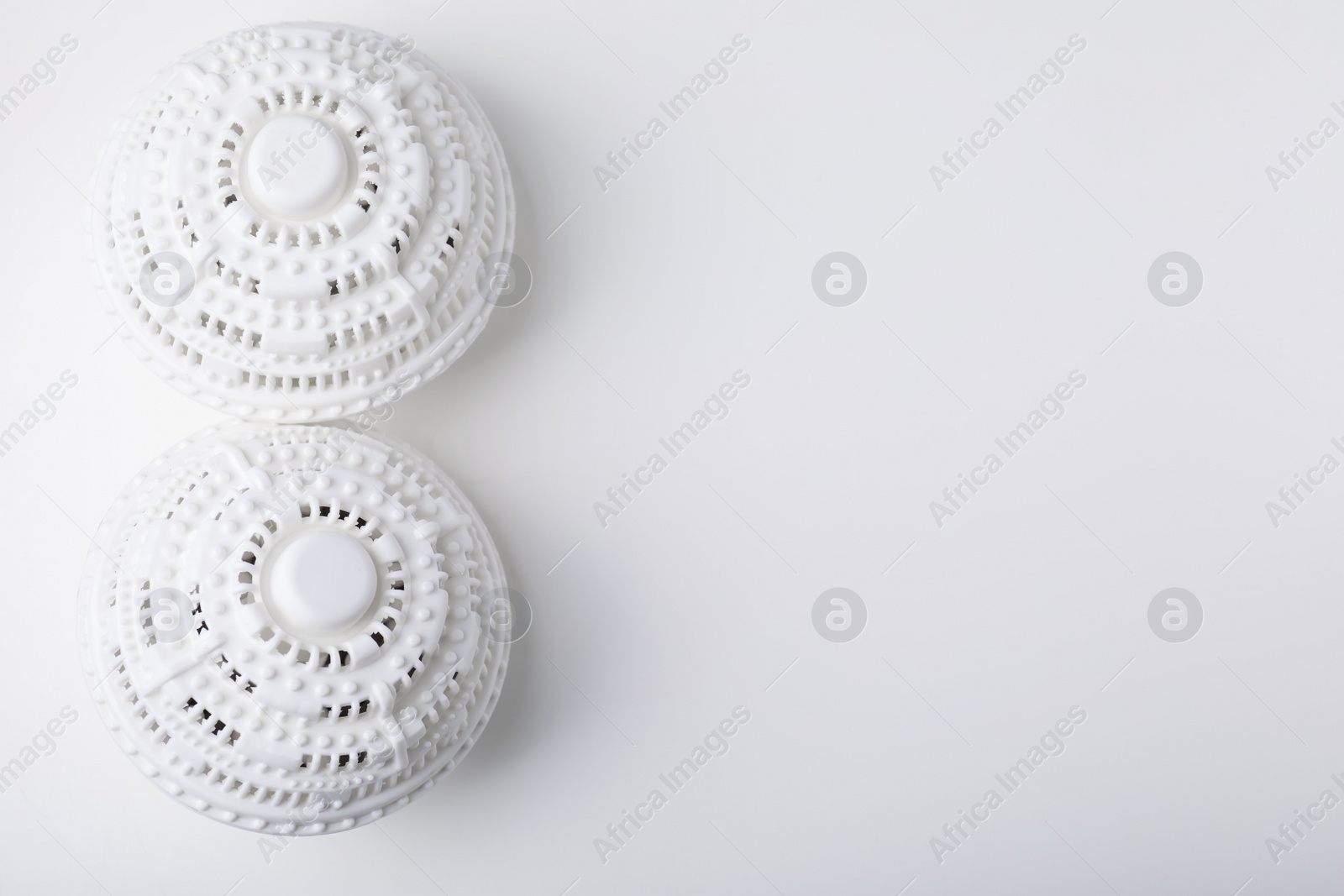 Photo of Laundry dryer balls on white table, flat lay. Space for text