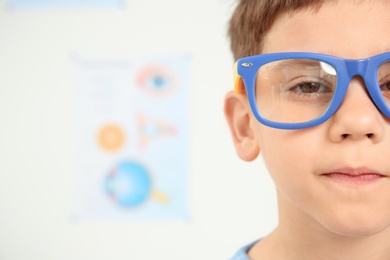 Photo of Cute little boy with glasses visiting ophthalmologist