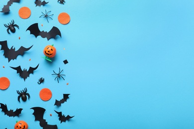 Photo of Halloween decor elements on light blue background, flat lay. Space for text