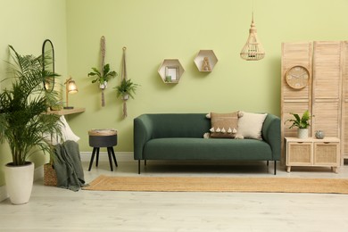 Living room with comfortable green sofa. Interior design