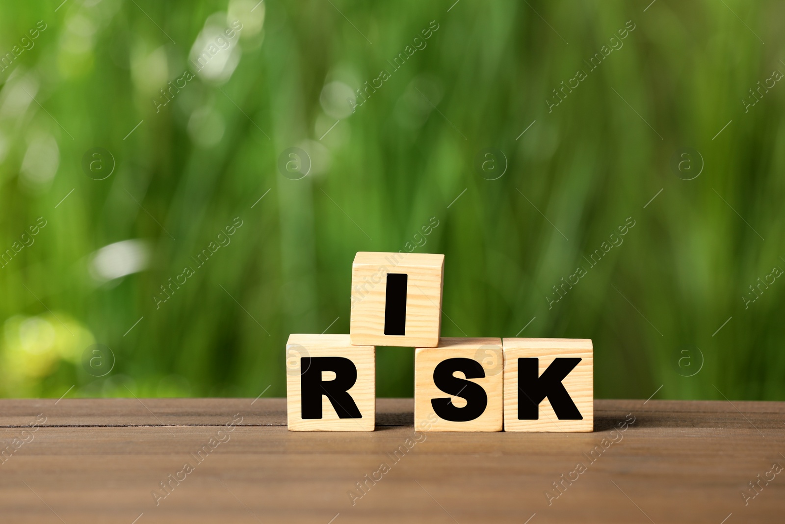 Photo of Cubes with word Risk on wooden table