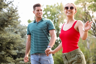 Lovely couple walking together in park on sunny day