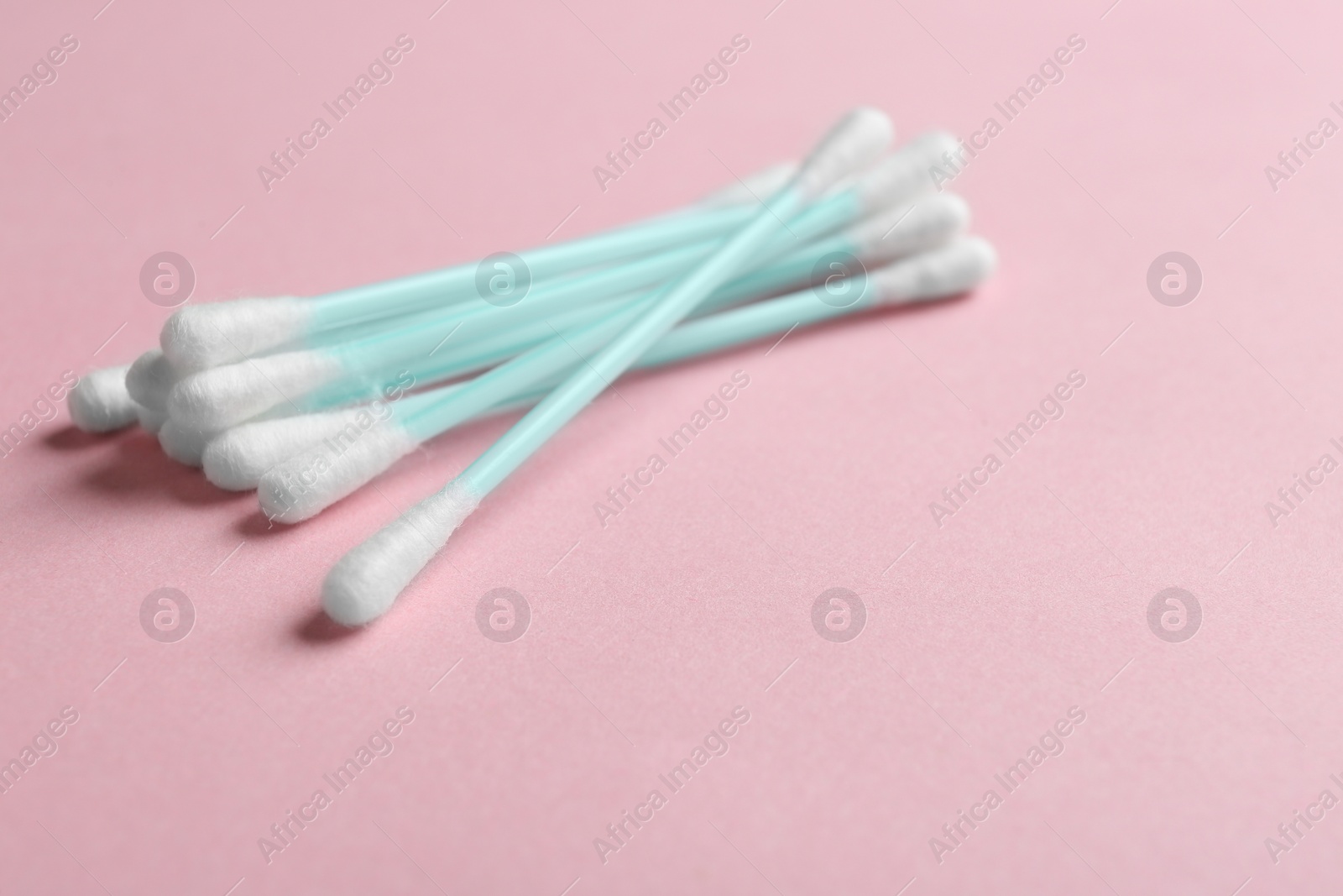 Photo of Pile of cotton swabs and space for text on color background