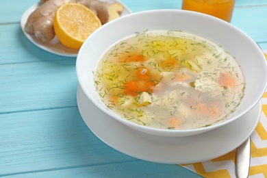 Photo of Bowl of fresh homemade soup to cure flu on wooden table