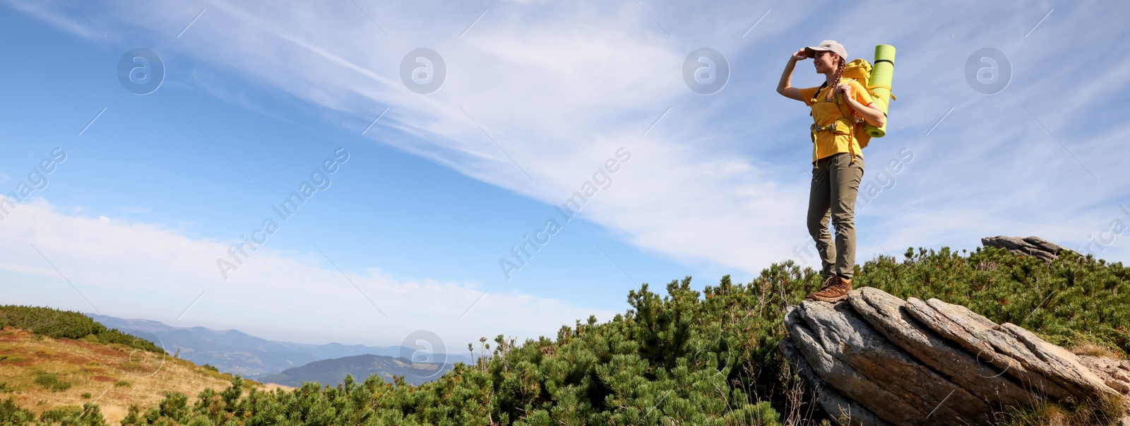 Image of Young woman with backpack in mountains, banner design