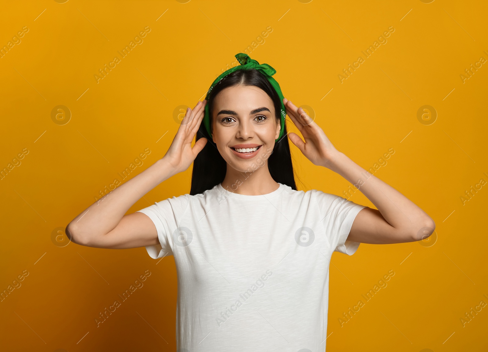 Photo of Young woman wearing stylish bandana on orange background