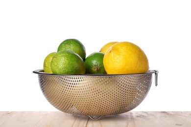 Photo of Fresh fruits in colander on wooden table against white background