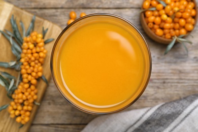 Delicious sea buckthorn juice on wooden table, top view