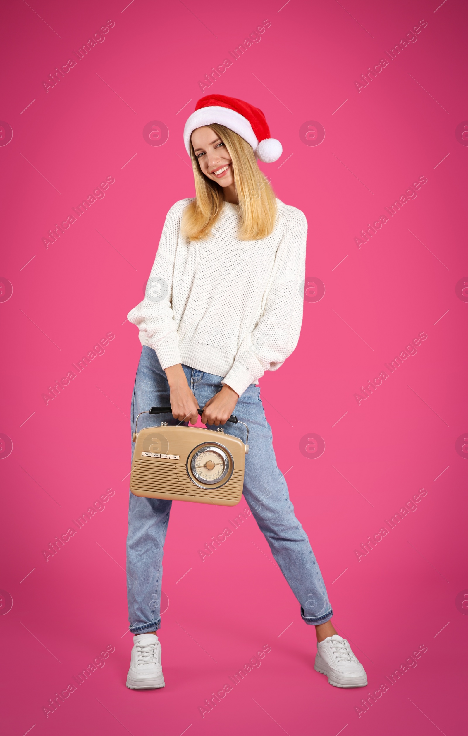 Photo of Happy woman with vintage radio on pink background. Christmas music