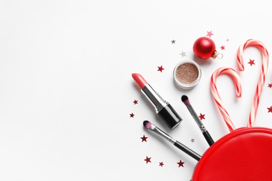 Flat lay composition with makeup products and Christmas decor on white background. Space for text