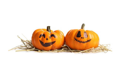 Photo of Cute Halloween pumpkins and straw on white background