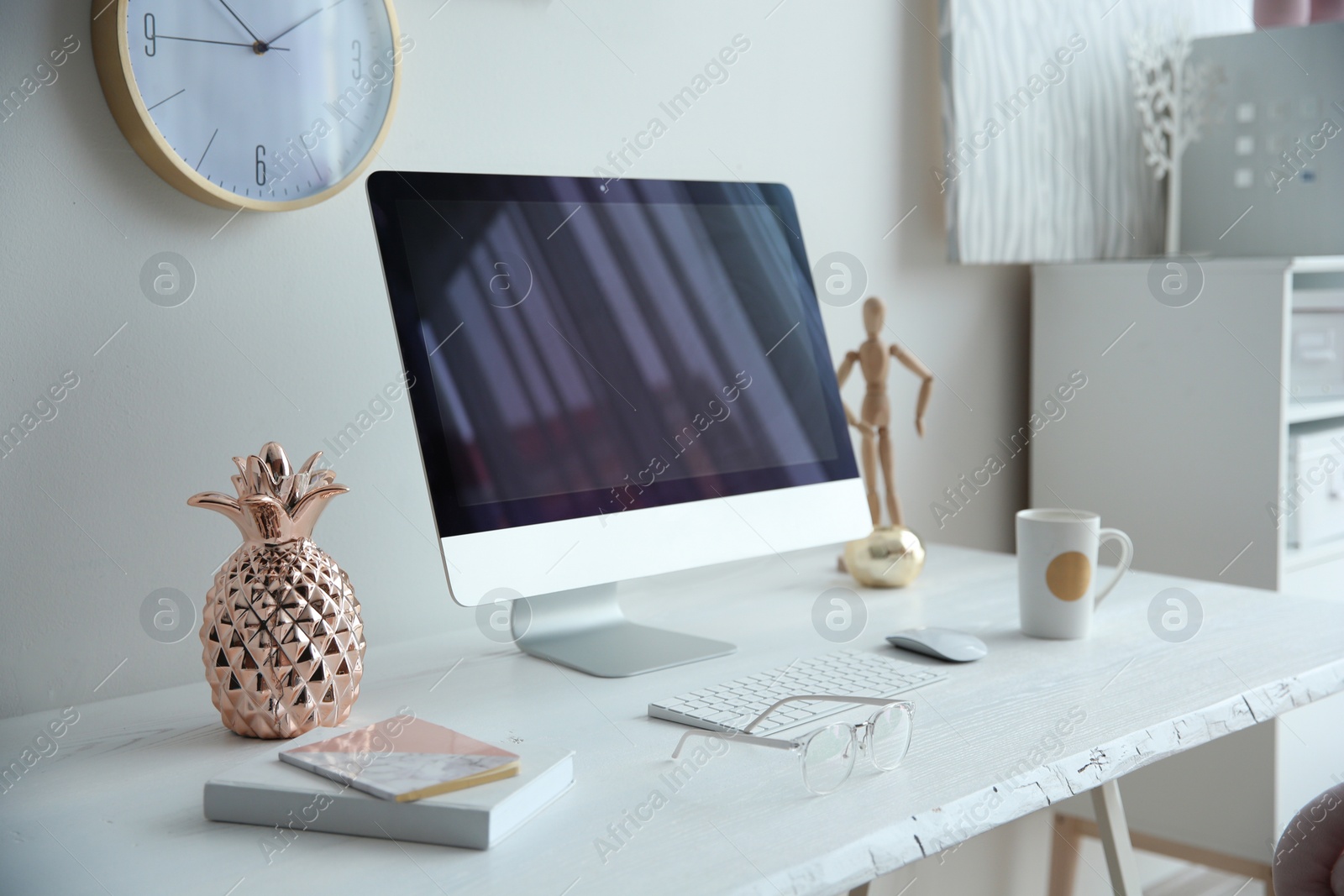 Photo of Contemporary workplace with computer on table near white wall. Interior design