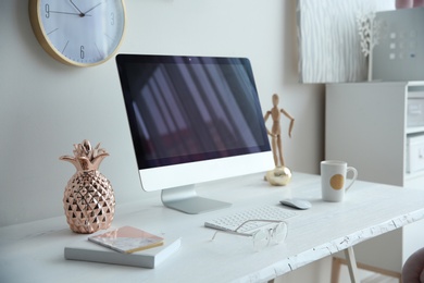 Contemporary workplace with computer on table near white wall. Interior design