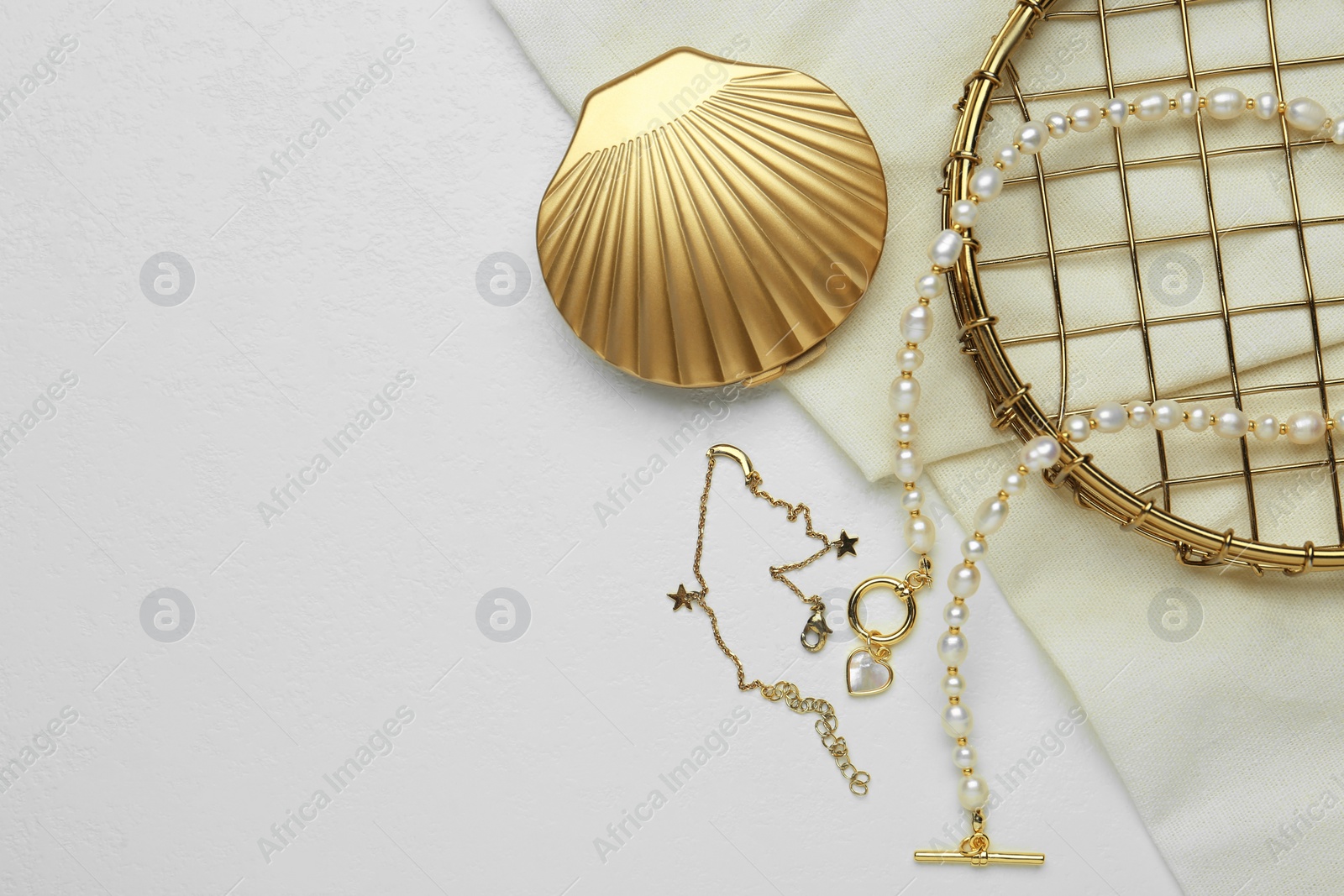 Photo of Different elegant jewelry and cosmetic pocket mirror on white table, flat lay. Space for text