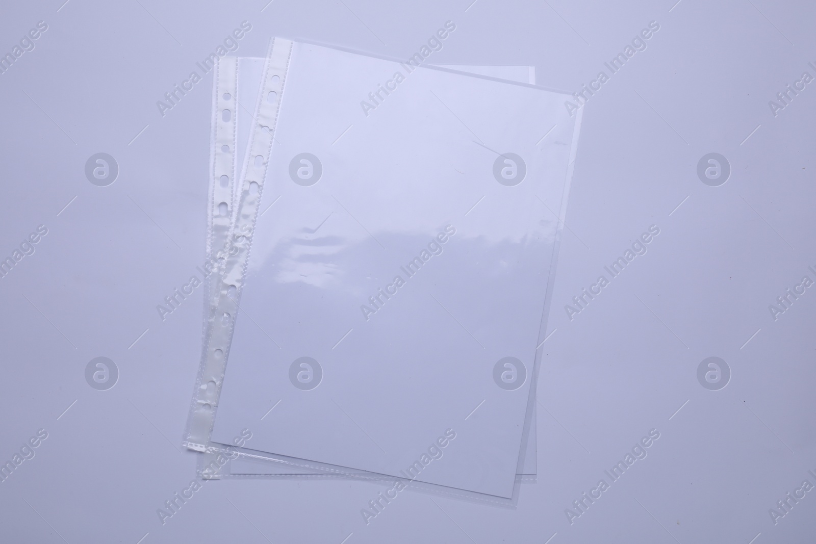 Photo of Punched pockets with paper sheets isolated on white, top view