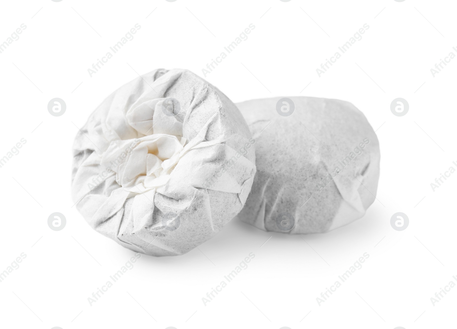 Photo of Cake shaped traditional Chinese pu-erh tea in paper wrap isolated on white