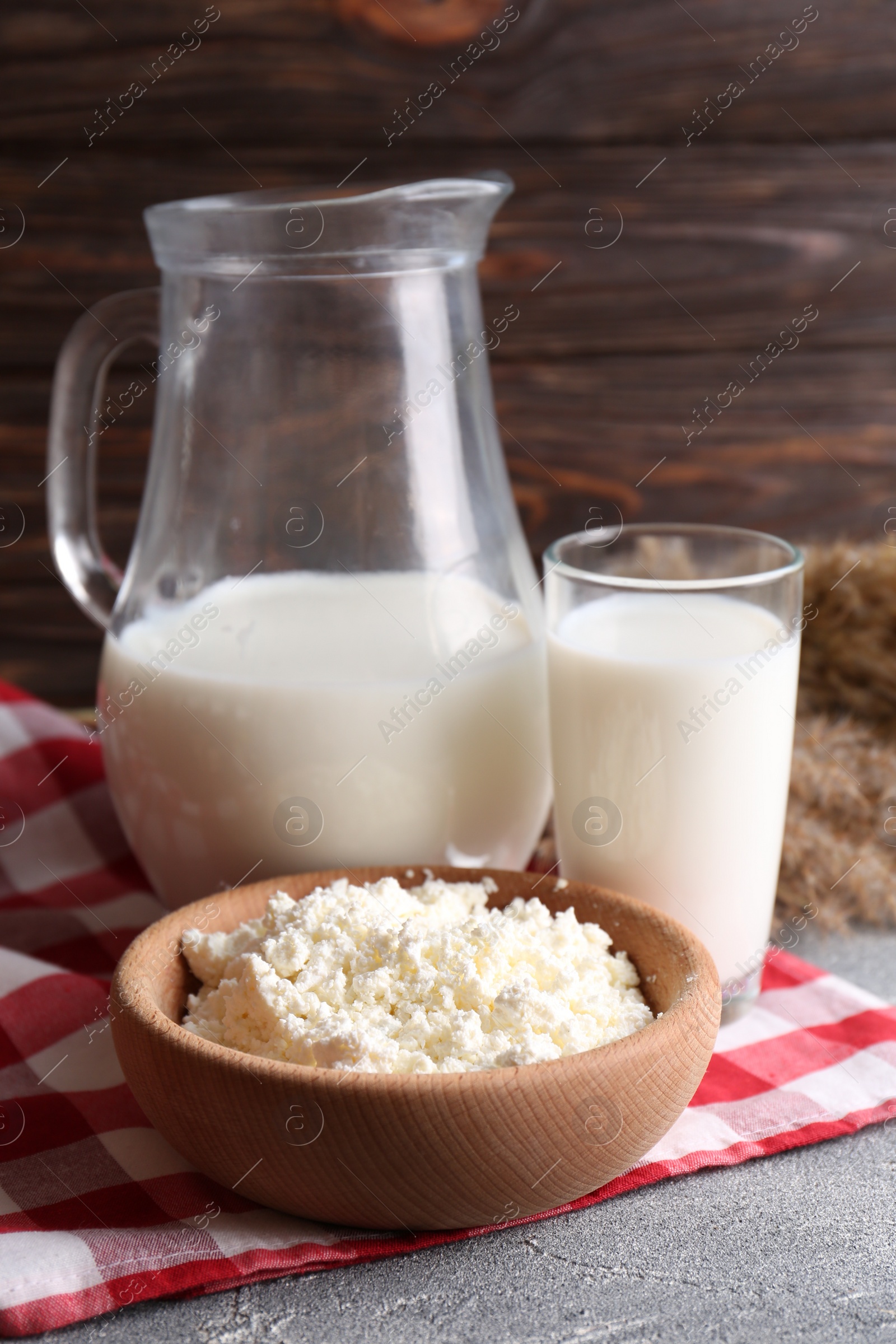 Photo of Tasty fresh milk and cottage cheese on grey table