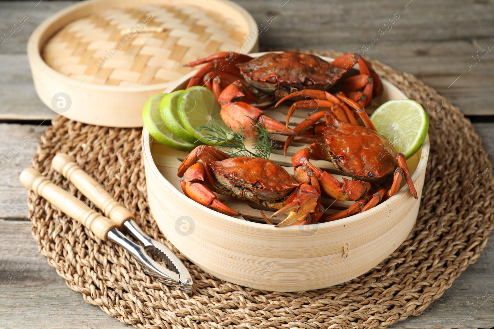 Photo of Delicious boiled crabs with lime and dill served on wooden table