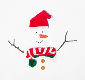 Photo of Creative snowman shape made of Santa hat and different items on white background, flat lay