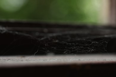 Photo of Cobweb on old wooden window frame indoors, closeup