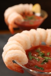 Tasty shrimp cocktail with sauce in glasses on blurred background, closeup