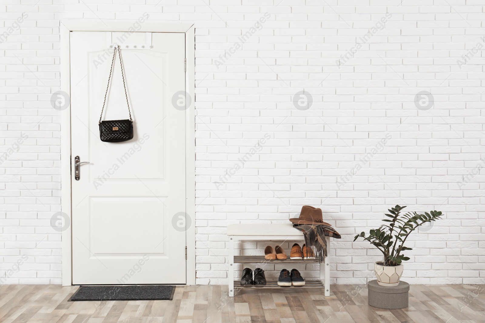 Photo of Hall interior with brick wall and white wooden door