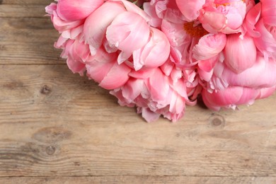 Photo of Beautiful pink peonies on wooden table, closeup. Space for text