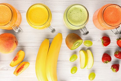 Photo of Many different tasty smoothies and ingredients on white wooden table, flat lay