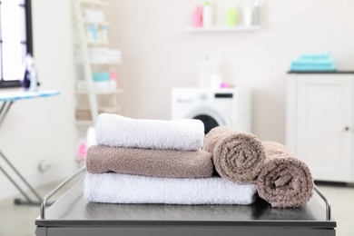 Soft bath towels on table against blurred background