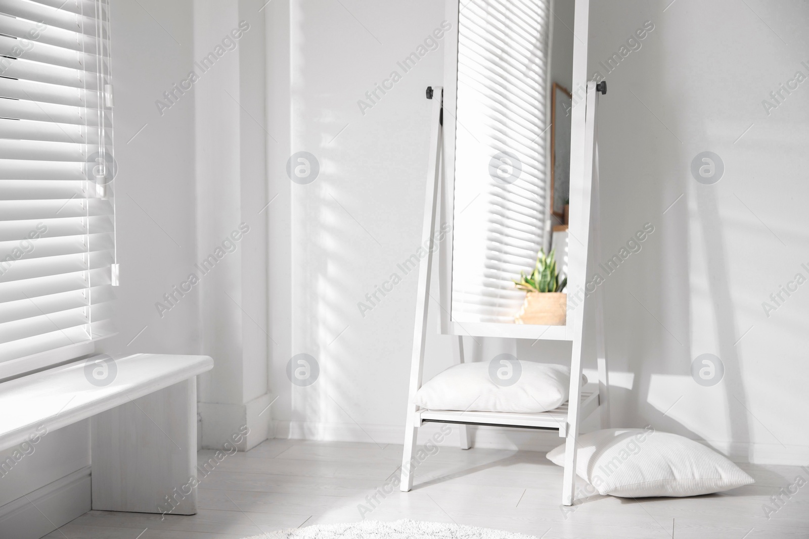 Photo of Large stylish mirror near white wall in room