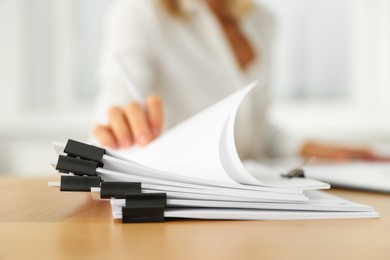 Woman working with documents at wooden table in office, closeup