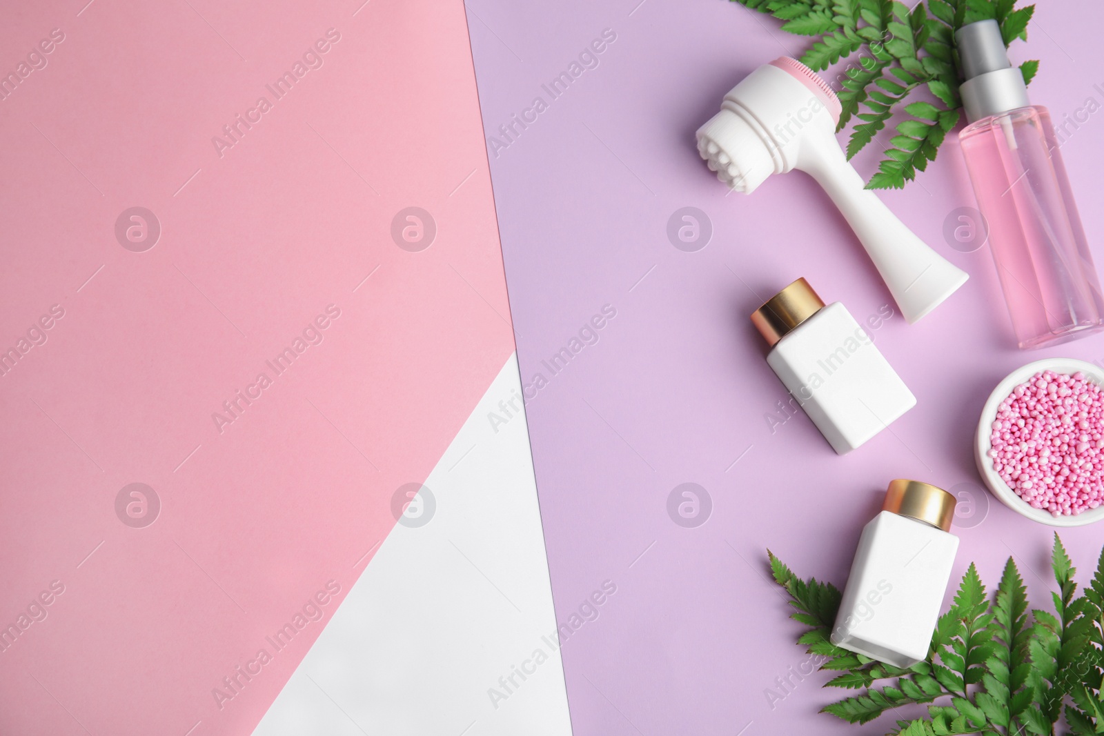 Photo of Flat lay composition with face cleansing brush on color background. Cosmetic accessory