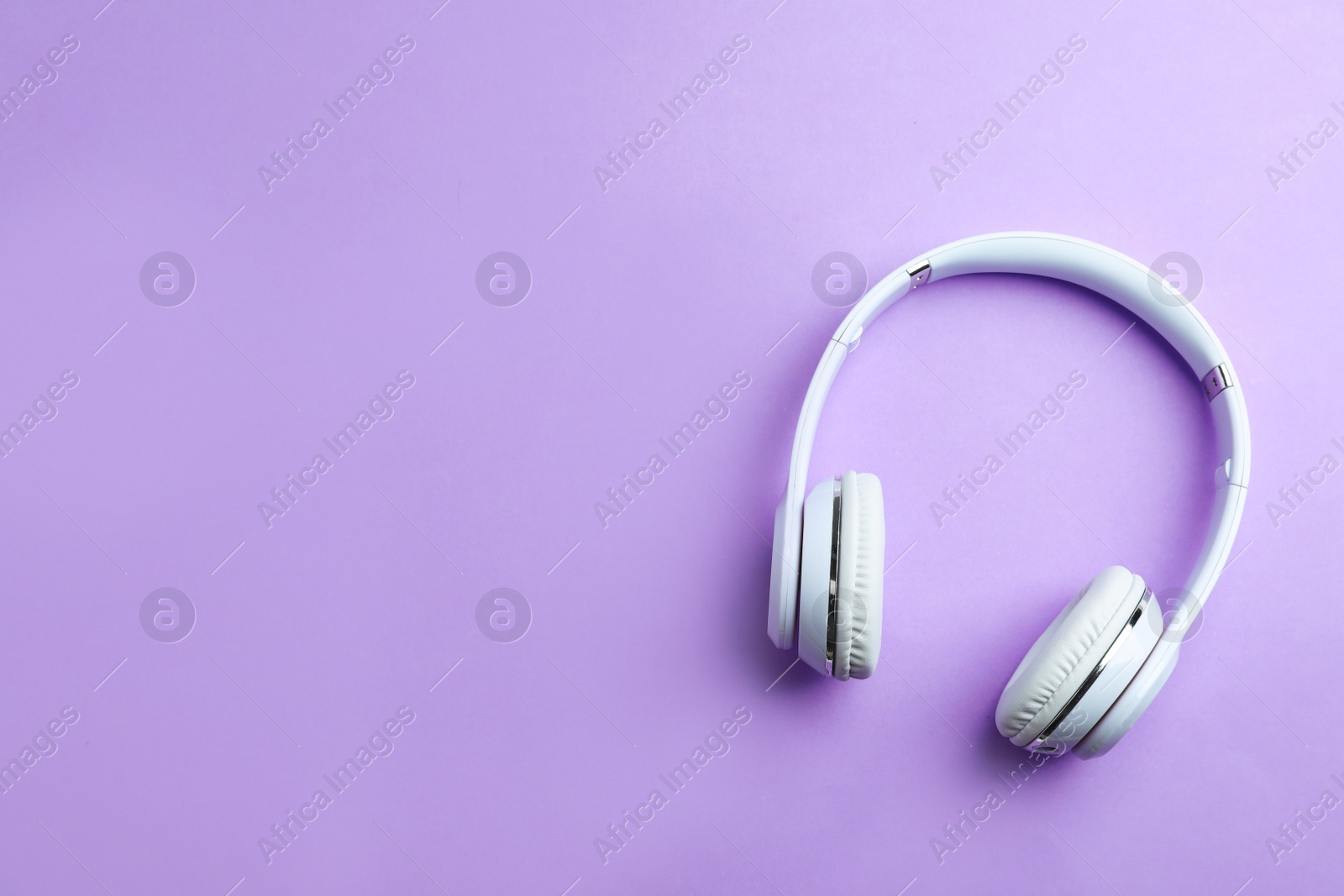 Photo of Wireless headphones on color background, top view. Space for text