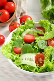 Photo of Delicious vegetable salad on white wooden table, closeup
