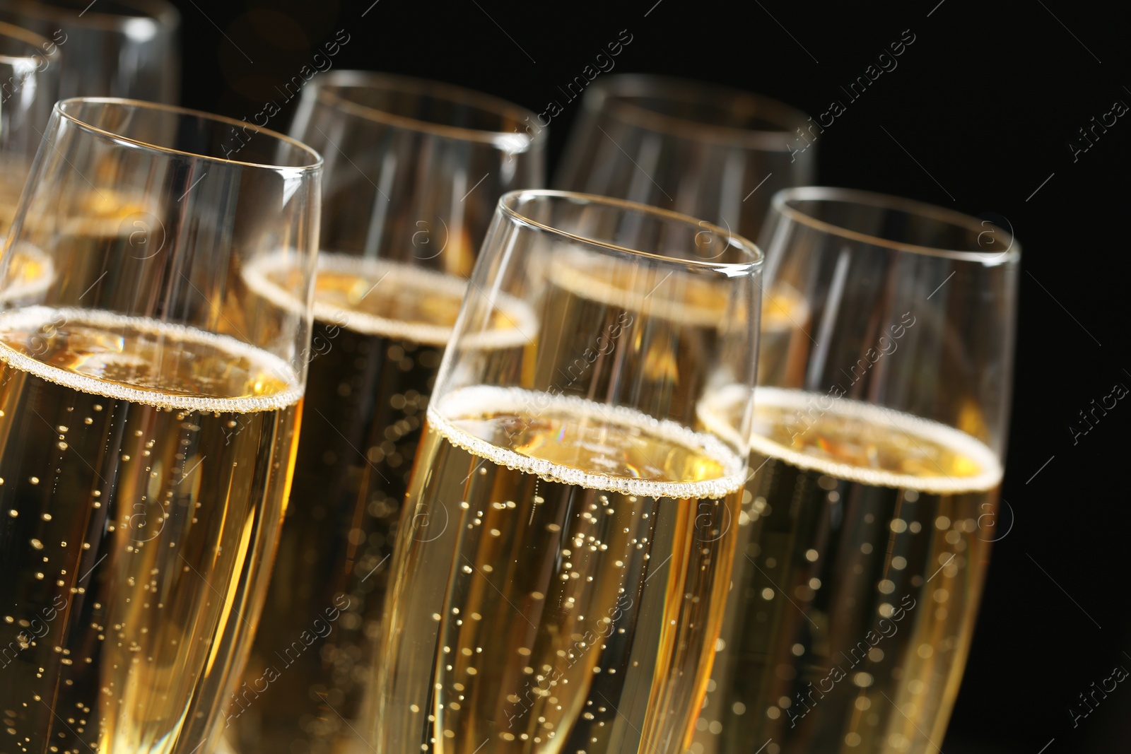 Photo of Glasses of champagne on dark background, closeup