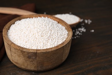 Photo of Tapioca pearls in bowl on wooden table, closeup