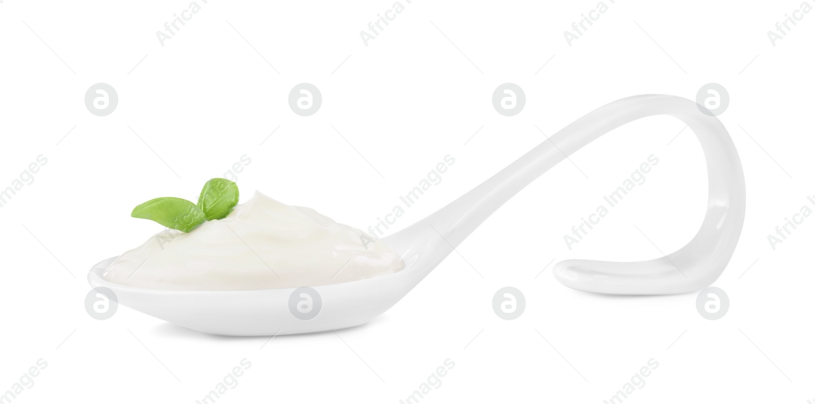 Photo of Delicious sour cream with basil in ceramic spoon on white background