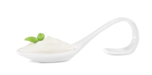 Photo of Delicious sour cream with basil in ceramic spoon on white background