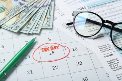 Photo of Calendar with date reminder about tax day, documents, pen, glasses and money, above view