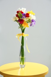 Photo of Beautiful freesia bouquet in vase on table